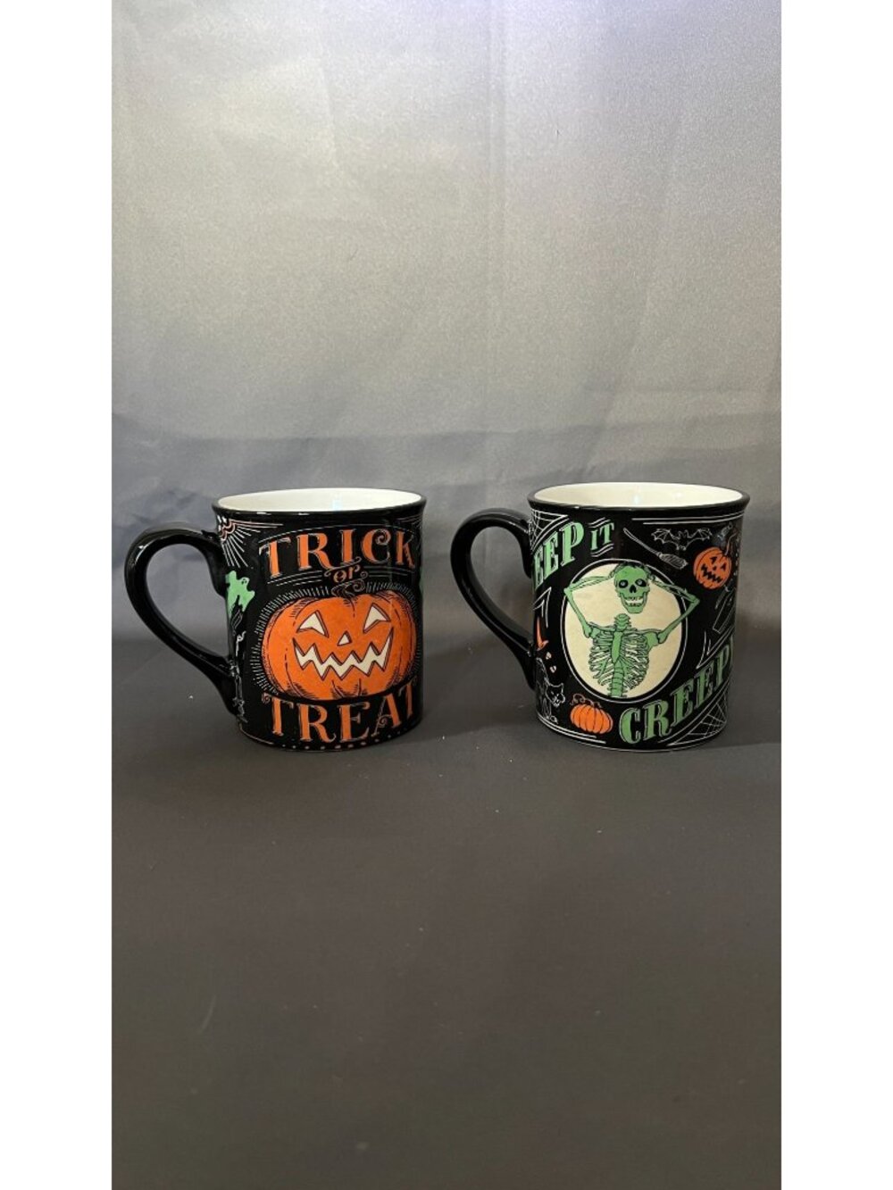 Set Of Two Halloween Mugs Featuring Festive Trick Or Treat & Skeletal Design